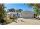 Welcoming single-story home featuring a two-car garage, tidy landscaping, and an American flag at 2760 Siesta Dr, Venice, FL 34293