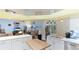 Open-concept kitchen with white cabinets, stainless steel appliances, and island for entertaining at 2760 Siesta Dr, Venice, FL 34293
