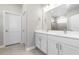 Bright bathroom with double sink vanity, white cabinets, quartz counters, and a glass-enclosed shower at 3166 Cabo St, North Port, FL 34291