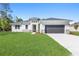 Beautiful new construction home with stone accents, a gray garage door, and a bright green lawn at 3166 Cabo St, North Port, FL 34291