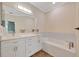 Bright bathroom features a soaking tub, white cabinets, and a large mirror over the vanity at 3872 Mira Lago Dr, Sarasota, FL 34238