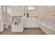 This bathroom features white cabinets, large mirror, soaking tub, and tiled floors at 3872 Mira Lago Dr, Sarasota, FL 34238
