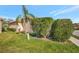 Exterior side view of the house featuring lush bushes, palm tree, and a well-kept lawn at 3872 Mira Lago Dr, Sarasota, FL 34238