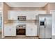 Modern kitchen with stainless steel appliances, white cabinets, and ample storage space at 3872 Mira Lago Dr, Sarasota, FL 34238