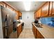 Galley kitchen with stainless steel appliances and wooden cabinetry at 4053 Crockers Lake Blvd # 2418, Sarasota, FL 34238