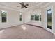 Bright, carpeted main bedroom with a tray ceiling, multiple windows, and an ensuite bathroom at 4307 70Th E Ave, Ellenton, FL 34222