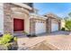 Inviting entryway with a vibrant red double door, brick accents, and a well-lit three-car garage at 4307 70Th E Ave, Ellenton, FL 34222