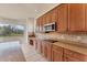 Kitchen featuring hardwood cabinets, granite countertops, stainless steel appliances, and a bay window with a scenic view at 4307 70Th E Ave, Ellenton, FL 34222