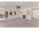 Spacious living room with neutral carpet, fireplace, ceiling fan, and views into the adjacent kitchen area at 4307 70Th E Ave, Ellenton, FL 34222