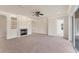 Open-concept living room with fireplace, neutral carpet, large windows, and modern lighting fixtures at 4307 70Th E Ave, Ellenton, FL 34222