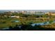 Picturesque aerial view of a golf course, a river, and city landscape beyond lush trees at 435 L Ambiance Dr # L807, Longboat Key, FL 34228