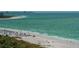 Beach view of beachgoers, chairs and umbrellas in the white sand at 435 L Ambiance Dr # L807, Longboat Key, FL 34228