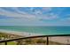 Expansive beach view with turquoise water, white sand, and palm trees from a balcony at 435 L Ambiance Dr # L807, Longboat Key, FL 34228
