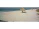 Sandy beach with tiki umbrellas and lounge chairs, ocean view at 435 L Ambiance Dr # L807, Longboat Key, FL 34228