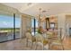 Elegant dining area with chandelier, glass table, and stunning views from large balcony at 435 L Ambiance Dr # L807, Longboat Key, FL 34228