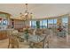 Bright dining room with ocean view, chandelier, glass table, and decorative furnishings at 435 L Ambiance Dr # L807, Longboat Key, FL 34228