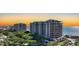 Striking exterior elevation of beachfront condos with lush landscaping and stunning sunset view at 435 L Ambiance Dr # L807, Longboat Key, FL 34228