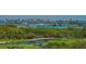 Lush green golf course with water features and city skyline backdrop at 435 L Ambiance Dr # L807, Longboat Key, FL 34228