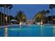 Beautifully lit community pool surrounded by tall palm trees at 435 L Ambiance Dr # L807, Longboat Key, FL 34228