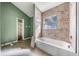 Bathroom with full tub, tile surround, and built-in shelving at 445 88Th N Ave, St Petersburg, FL 33702