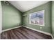 Bedroom with wood-look flooring, a window, and green walls at 445 88Th N Ave, St Petersburg, FL 33702