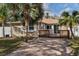 Charming bungalow with a brick driveway, a cozy deck, and lush tropical landscaping at 445 88Th N Ave, St Petersburg, FL 33702