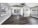 Bright living room features modern gray walls, wood-look floors, and a ceiling fan at 445 88Th N Ave, St Petersburg, FL 33702