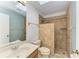 Bathroom featuring a sink, toilet, tiled shower and decorative hardware at 4920 82Nd E Pl, Sarasota, FL 34243