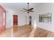 Cozy bedroom featuring light wood floors, a ceiling fan, and natural light from a window at 4920 82Nd E Pl, Sarasota, FL 34243