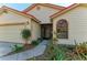 Close-up of home's exterior featuring a garage, decorative windows, and garden beds at 4920 82Nd E Pl, Sarasota, FL 34243