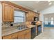Open kitchen featuring wood cabinetry, granite countertops, and stainless steel appliances at 4920 82Nd E Pl, Sarasota, FL 34243