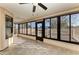 Bright sunroom features tile floors, ceiling fan, and large windows leading to an outdoor deck at 4920 82Nd E Pl, Sarasota, FL 34243