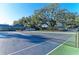 Well-maintained tennis court surrounded by trees, perfect for recreational activities at 4920 82Nd E Pl, Sarasota, FL 34243