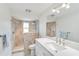 Bright bathroom with double sinks, walk-in shower, and stone tile at 5107 Saint Albans Ave, Sarasota, FL 34242