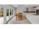 Dining room with a wooden table and chairs adjacent to a bright kitchen with white cabinets at 5107 Saint Albans Ave, Sarasota, FL 34242