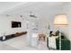 A bright, open living room features track lighting, a green sofa and light flooring at 5107 Saint Albans Ave, Sarasota, FL 34242