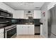 Updated kitchen features white cabinets, black backsplash, and stainless steel appliances at 5282 Beach Se Dr # D, St Petersburg, FL 33705