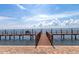 Scenic view of a private wooden pier with a chair extending into the calm ocean waters under a partly cloudy sky at 5282 Beach Se Dr # D, St Petersburg, FL 33705