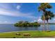 Picturesque water view showcasing lush island, condos, palm trees, and serene seating areas at 5282 Beach Se Dr # D, St Petersburg, FL 33705