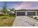 Two-car garage home with gray exterior and paver driveway at 5429 Mystic Water Cv, Bradenton, FL 34211