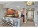 Well-lit kitchen with dark wood cabinets, granite countertops, and bar seating area at 5531 Cannes Cir # 605, Sarasota, FL 34231