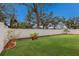 Expansive backyard showcasing a manicured lawn and a pristine white fence for privacy at 5809 71St E St, Palmetto, FL 34221