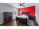 Bedroom showcasing a red accent wall, wood floors, and matching furniture at 5809 71St E St, Palmetto, FL 34221