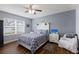 Bright bedroom with a large window, a bed with patterned bedding, and a white chair and nightstand at 5809 71St E St, Palmetto, FL 34221