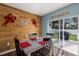 Dining room with wood paneling and decor leads to an outdoor patio with a grill and fenced yard at 5809 71St E St, Palmetto, FL 34221