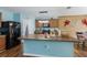 Well-lit kitchen with a large center island, wooden cabinets, and modern black appliances at 5809 71St E St, Palmetto, FL 34221