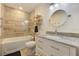 Bathroom with tiled shower-over-bath, marble counters, and wall fixtures at 6517 Approach Rd # 57, Sarasota, FL 34238