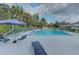 Outdoor pool with blue umbrella and lounge chairs for relaxing by the water at 6517 Approach Rd # 57, Sarasota, FL 34238