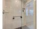 Luxurious glass shower with modern fixtures, built-in niche, and contrasting dark tile floor at 6517 Approach Rd # 57, Sarasota, FL 34238