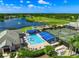 An aerial view features the community pools, tennis courts, lakes, and golf course surrounded by lush greenery at 6524 Fairway Gardens Dr # 6524, Bradenton, FL 34203